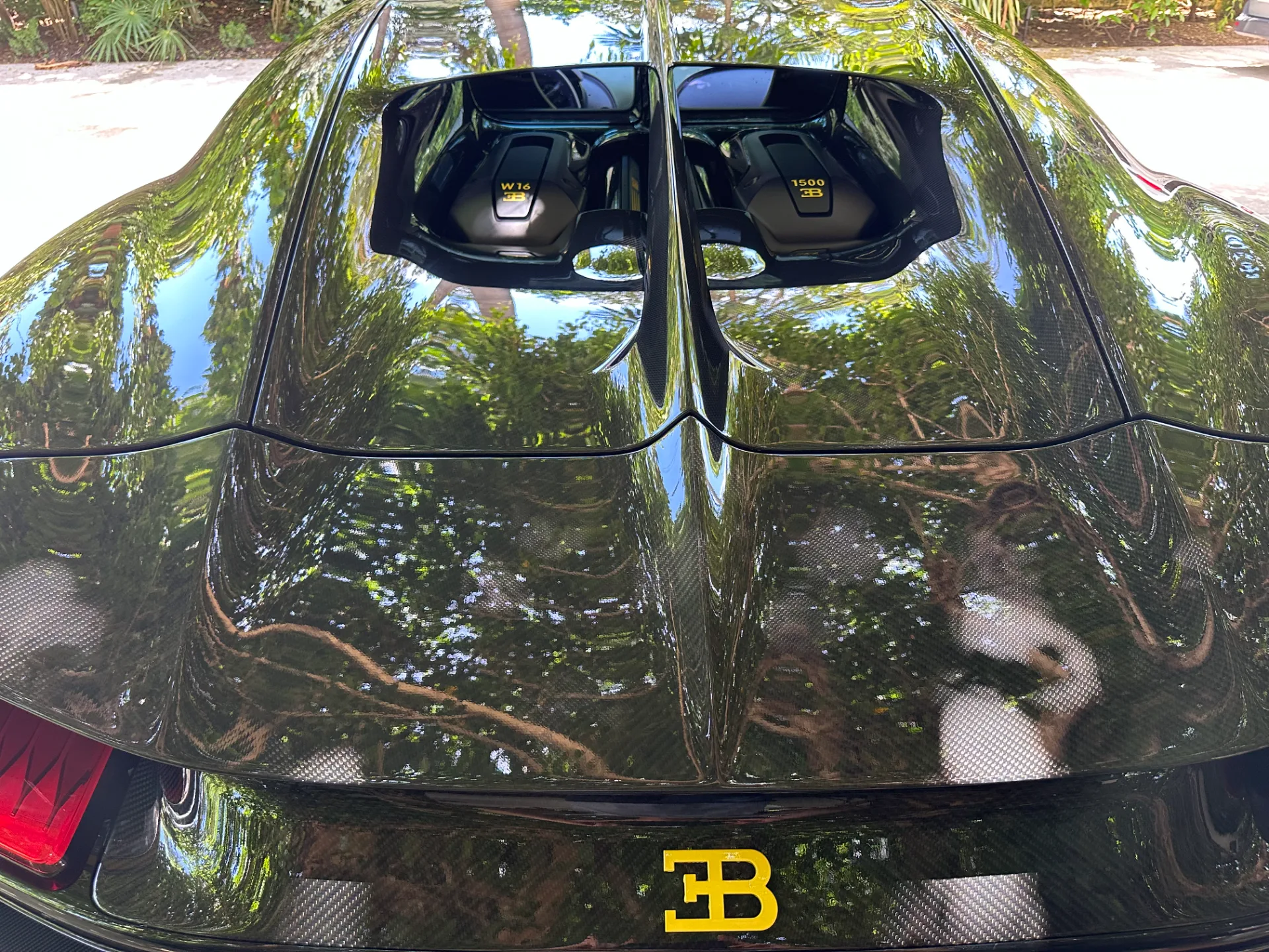 Exposed carbon engine cover of a Bugatti Chiron after detailing